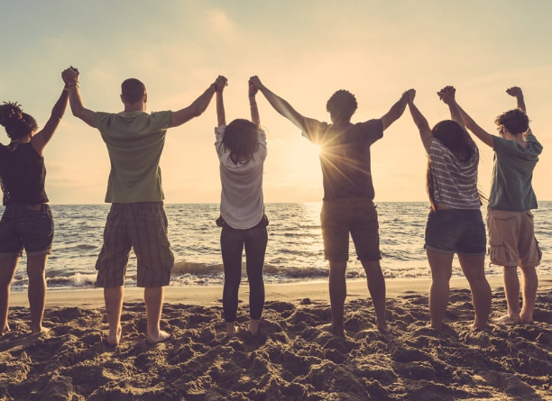 Group holding hands on beach