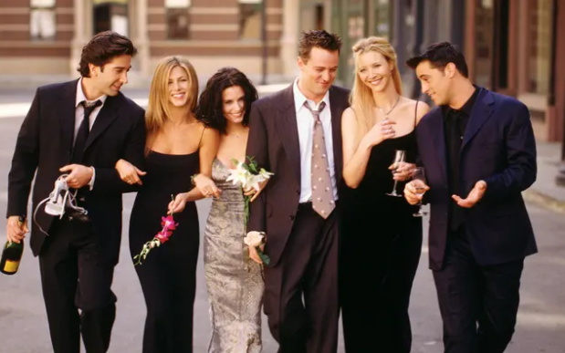 Friends cast celebrating together outdoors.