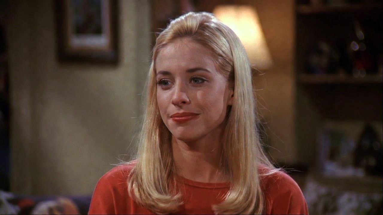 Jane Sibbett as Carol Willick in Friends, smiling confidently in the apartment